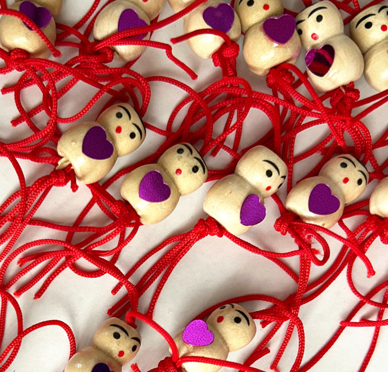 Gelukspoppetje met paars hartje op de buik